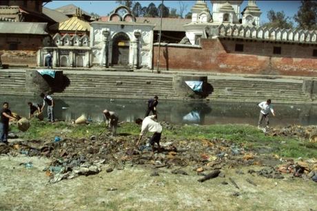 Volunteers clearing the Bagmati banks with the Pashupatinath temple behind, Aryaghat