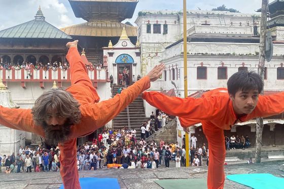 Students and teachers practising yoga together on mats in the courtyard at Pashupatinath