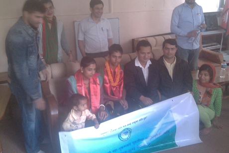 Guests in garlands seated behind a New Vision Nepal banner at the honouring programme