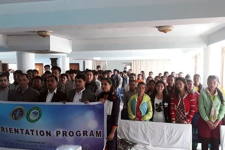 Participants standing in a long row behind the Youth Orientation Program banner