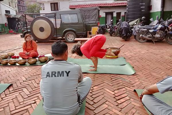 A free session under way in an open yard, singing bowls laid out on a mat