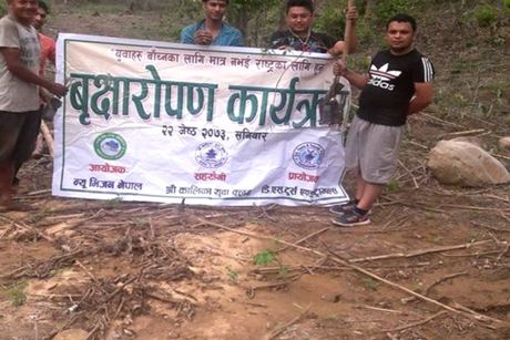 The tree-planting banner on the cleared Phujel hillside